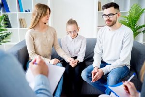 Family sitting on couch during family therapy
