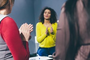 Three women participate in a group activity at the best mental health clinic Houston offers