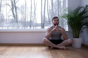 A man meditates on the floor as a part of what he learned from his Houston panic attack therapy psychiatrist
