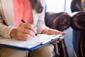 a woman takes notes during an outpatient psychiatry appointment at our outpatient psychiatry clinic in Houston