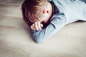 a child lays on the floor during a pervasive developmental disorder therapy session with a pervasive developmental disorder psychiatrist
